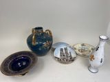 trois vases et une assiette posés sur une table