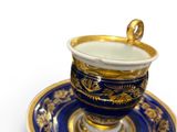 a blue and gold cup and saucer on a saucer