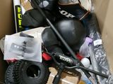 une boîte en carton contenant divers articles, notamment un snowboard, des skis, des bâtons et un casque