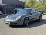 a silver porsche parked in a parking lot