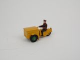 un petit camion jaune sur lequel est assis un homme