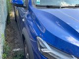 a blue car that is parked next to a fence