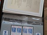 une boîte de timbres posée sur une table à côté d'une paire de ciseaux