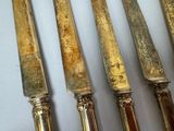 five knives that are sitting on a table
