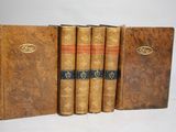 quatre vieux livres sont alignés sur une surface blanche
