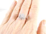 a woman ' s hand with a diamond ring on it