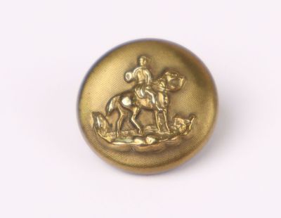a gold button with a horse and rider on it