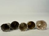 three silver vases sitting next to each other on a white surface