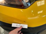 a hand that is holding a sticker on the front of a yellow car