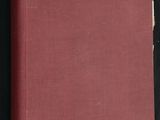 un livre rouge posé sur une table recouverte d'un tissu noir