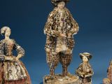 three figurines of a man and a woman and a child
