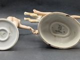 two porcelain figurines that are sitting next to each other