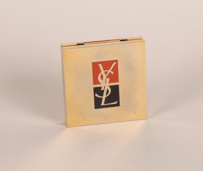 logo Saint Laurent sur un coffret doré posé sur un fond blanc