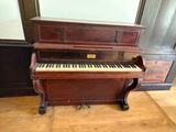 a piano that is sitting on a wooden floor