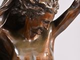 bronze statue of a woman holding a candle in her right hand