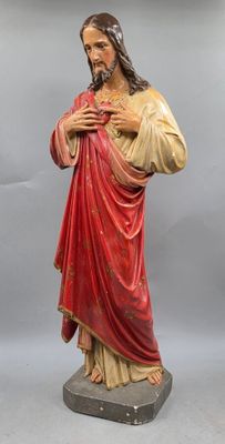 a statue of jesus holding a cross on a pedestal