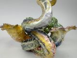 a figurine of a bird sitting on top of a pile of bananas