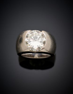 un gros plan d'une bague sertie d'un diamant sur une surface noire