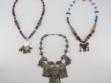 three necklaces and a necklace with a bird on it