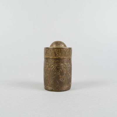 une petite boîte en laiton ornée d'un motif sur le couvercle