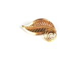 broche en feuille d'or avec un motif en spirale sur fond blanc