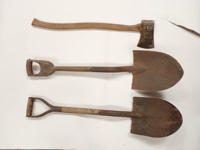 trois vieux outils sont posés sur une surface blanche