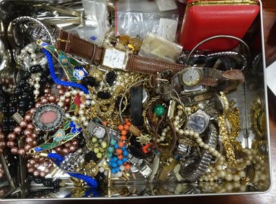 une boîte en métal remplie de bijoux variés, posée sur une table