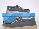 men ' s blue canvas boat shoes with tan soles on top of a blue box