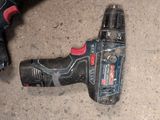 a drill that is laying on the ground next to a cordless drill