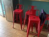 three red chairs sitting in front of a counter