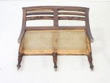 a wooden bench with a wicker seat on top of it