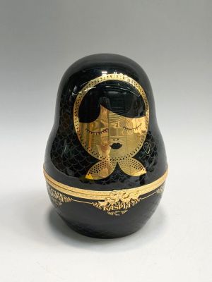 a black and gold matry with a woman ' s face painted on it
