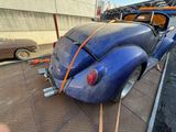 a blue car that is being towed by a tow truck