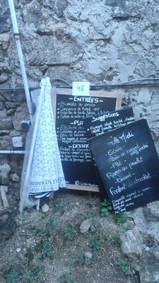 a blackboard with a menu on it sitting on the ground