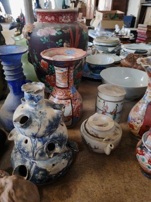 de nombreux vases et bols sur la table de cette pièce