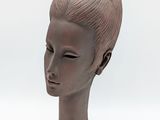 sculpture représentant la tête d'une femme sur fond blanc