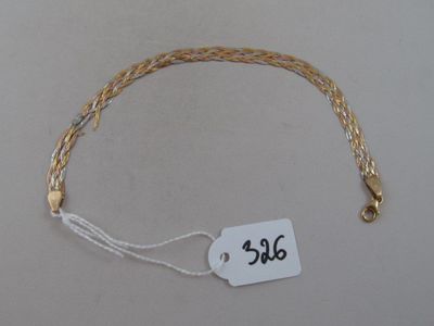 a gold bracelet with a tag on it on a table