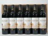 six bottles of red wine in a wooden box on a table
