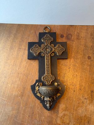 a cross hanging on a wall on a wooden table