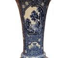 a blue and white vase sitting on a white surface
