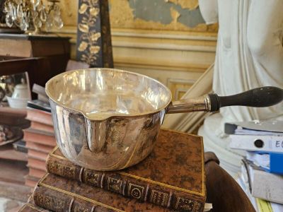 un bol en argent posé sur une pile de livres
