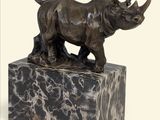 statue d'un rhinocéros debout sur un bloc de marbre, sur fond blanc