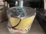 un seau de nourriture posé par terre devant une cuisinière