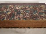 an old book with a floral cover on a bed