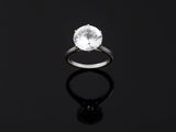 a white diamond ring on a black surface