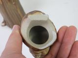 a person holding a small vase in their hand