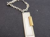 a silver and gold necklace with a chain on it