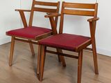 Deux chaises en bois, dotées de coussins rembourrés rouges, sont posées sur un parquet en bois massif.