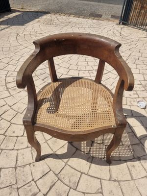 a wooden chair that is sitting on a brick patio