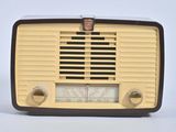une radio à l'ancienne posée sur un meuble blanc
